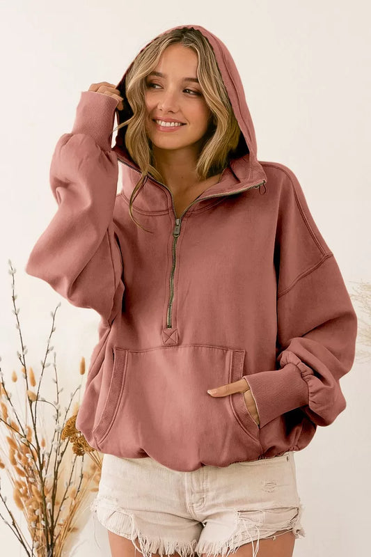 Woman wearing the BiBi terracotta color half zip fleece hoodie with a white background.