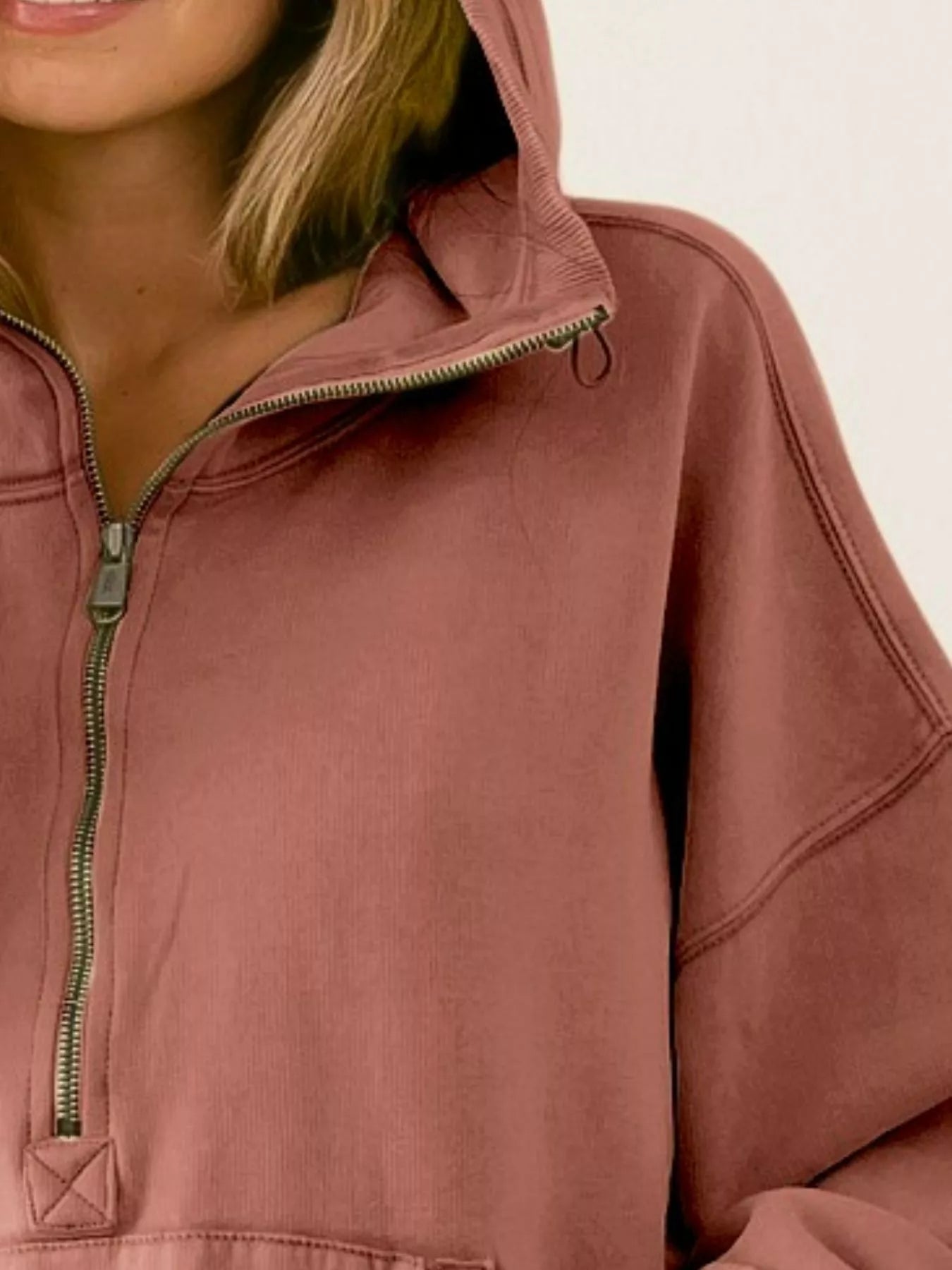 Detail shot of the BiBi terracotta color half zip fleece hoodie showing the zipper and shoulder area.